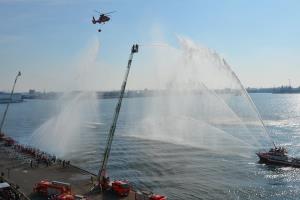 图片:云梯消防车和消防艇分别喷出水柱